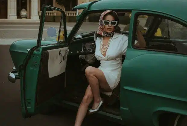 a woman sitting in the back of a green car