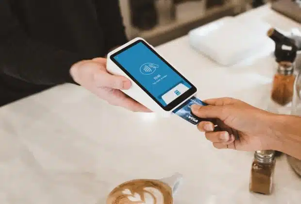 person putting magstripe card near black card terminal